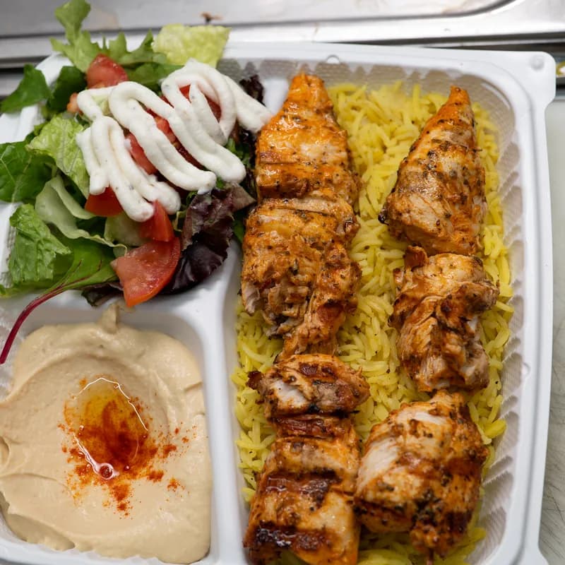 Chicken kabob over rice with hummus and house salad