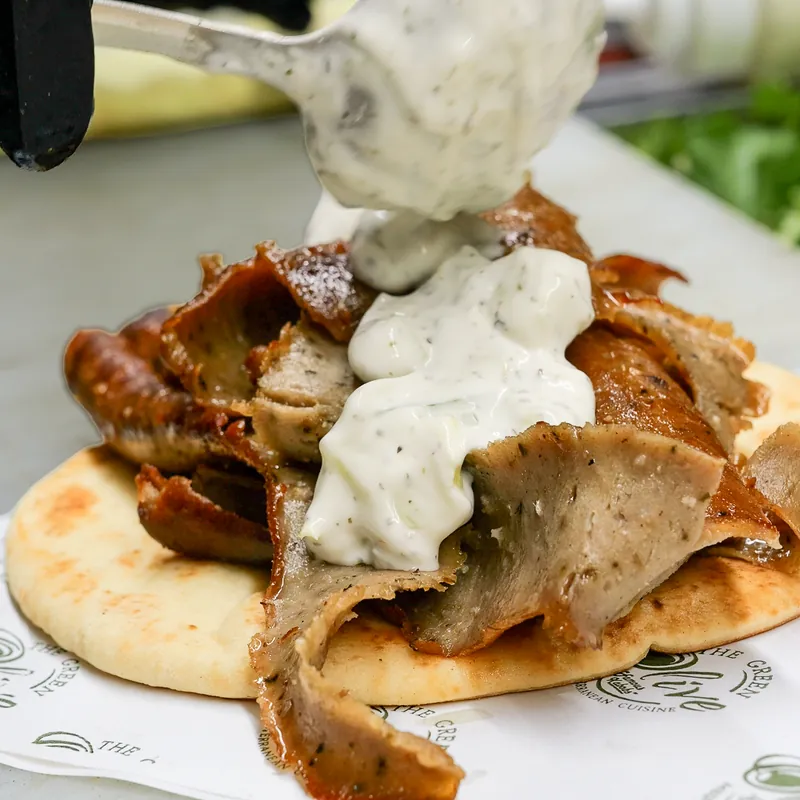 Gyro meat on warm pita with tzatziki