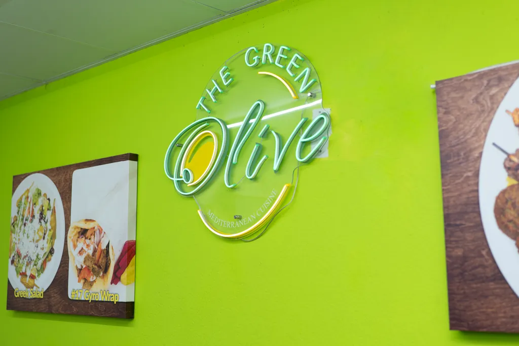 The Green Olive logo on the bright green dining room wall