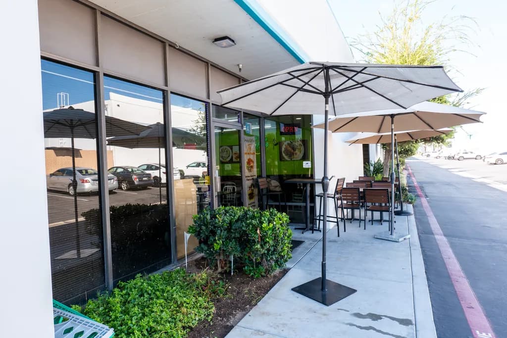 Patio tables and umbrellas outside The Green Olive on Stage Road